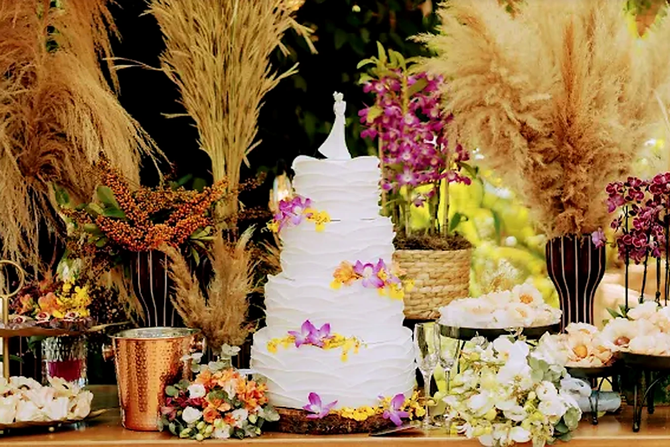 Mesa de casamento com bolo e arranjos florais
